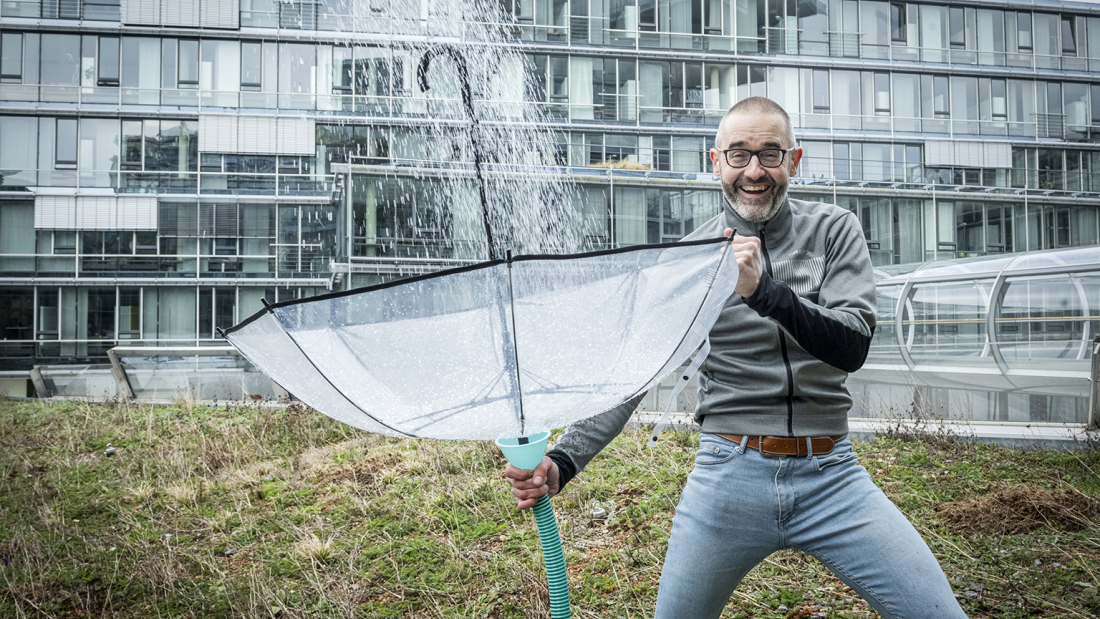 Das Foto zeigt Prof. Dr. Stephan Köster mit Regenschirm als Auffangbecken von Regen